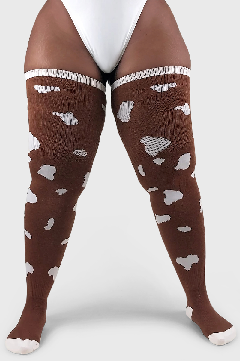 A pair of brown thigh-high socks with a cow print pattern, featuring white spots.